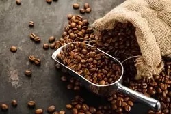 Kaffeelöffel aus Edelstahl mit frisch gerösteten Kaffeebohnen Kaffeelöffel aus Edelstahl mit frisch gerösteten Kaffeebohnen