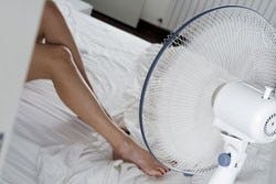 Frauenbeine werden durch einen Ventilator gekühlt Frauenbeine werden durch einen Ventilator gekühlt