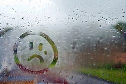 Nebeliges Fenster mit traurigem Smiley Nebeliges Fenster mit traurigem Smiley