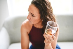 Depressive Frau mit einem Glas Alkohol in der Hand