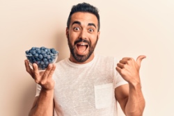 Man is blij met een schaaltje blauwe bessen