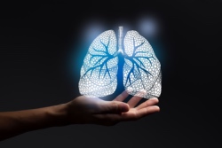 Abbildung einer Hand mit leuchtenden Lungen