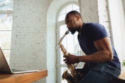 Mann bl&auml;st auf seinem Saxophon