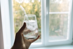 Hand, die ein gro&szlig;es Glas Wasser h&auml;lt