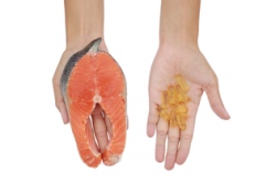 Hand in Hand mit Fisch und Hand mit Fisch&ouml;lkapseln