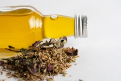 Eine liegende Flasche Oregano&ouml;l mit einem Bund Oregano