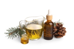 Kleine Flasche mit Extrakt aus dem Norwegischen Kiefernbaum, daneben Kiefernzapfen Kleine Flasche mit Extrakt aus dem Norwegischen Kiefernbaum, daneben Kiefernzapfen
