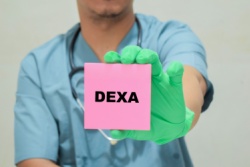 Der Arzt hält ein Blatt Papier mit der Aufschrift "Dexa-Scan" in den Händen. Der Arzt hält ein Blatt Papier mit der Aufschrift "Dexa-Scan" in den Händen.