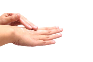 Frau schmiert ihre Hände mit Öl