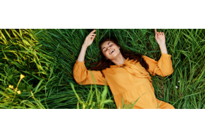 Frau liegt auf einer Wiese