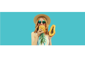 Die Frau hält Ananas und Papaya in ihren Händen