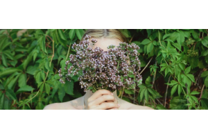 Vrouw met bos oregano voor haar gezicht