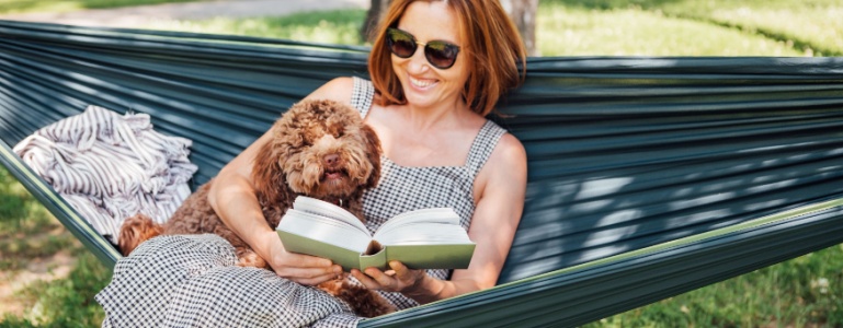 Frau liest ein Buch in einer Hängematte