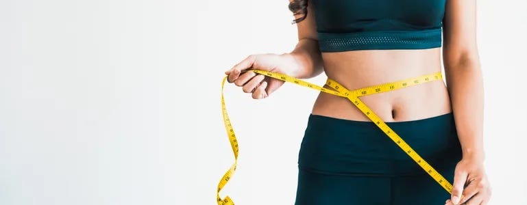 Frau mit Maßband um den Bauch