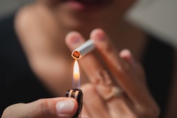 Eine Person z&uuml;ndet sich eine Zigarette an