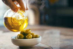 Extra vergine olijfolie wordt over olijven heen geschonken
