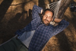 Mann liegt in einer Hängematte Mann liegt in einer Hängematte