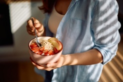 Frau hält Schüssel mit Haferflocken Frau hält Schüssel mit Haferflocken